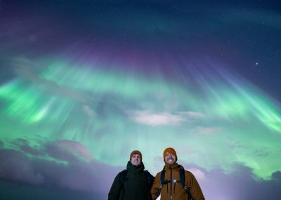 Visitors beneath colorful Northern Lights