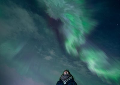 Northern Lights above a visitor in Iceland